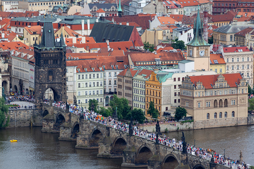 The Charles Bridge (Karluv most), the water clock tower, the old town bridge tower over Vitava river and the large dome of St francis of assisi church in Prague, Czech Republic.