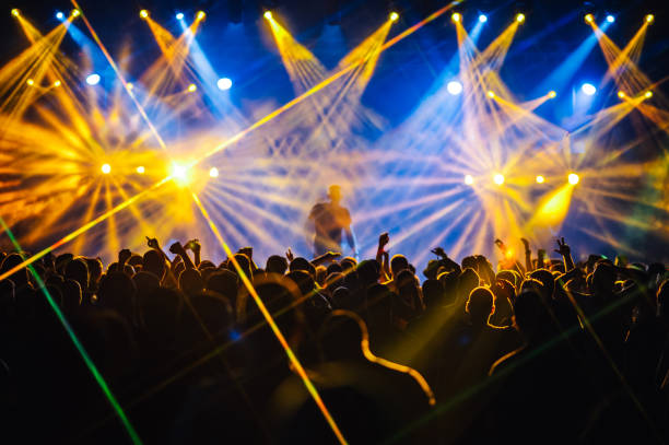 istock Silhouettes of people dancing during the concert while performer is on a stage 2097741915