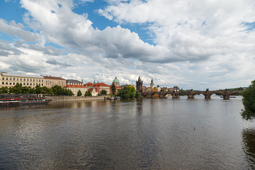 The Charles Bridge (Karluv most), the water clock tower, the old town bridge tower over Vitava river and the large dome of St francis of assisi church in Prague, Czech Republic.