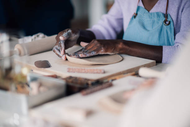 istock Interracial craftswoman's hands shaping wet clay on pottery class. 2097741961