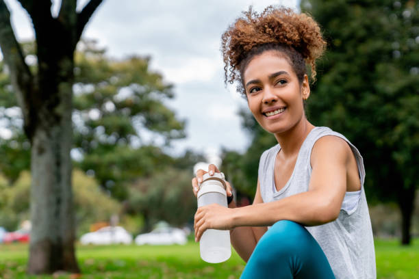 istock Female runner taking a break to drink water 2097798670