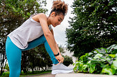 Female runner exercising at the park and tying her shoes