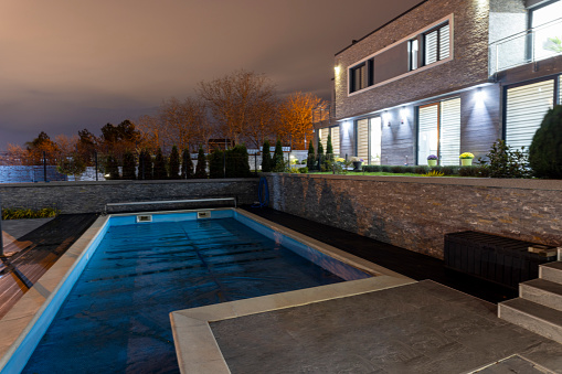 Luxurious white villa with a big pool, photographed at night