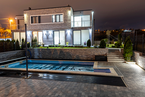 Modern family villa with swimming pool at night