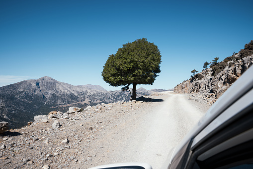 Driving on idyllic gravel road in Psiloritis mountain range, Crete, Greece.