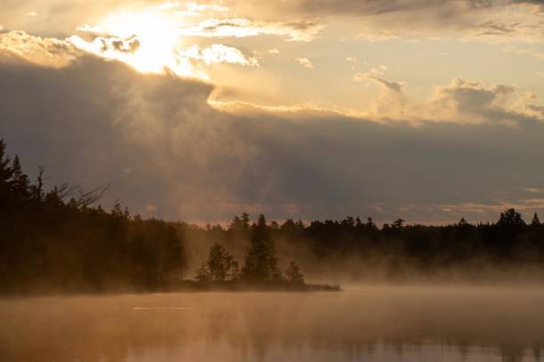 A brilliant sky over a northern Maine tranquil lake at dawn