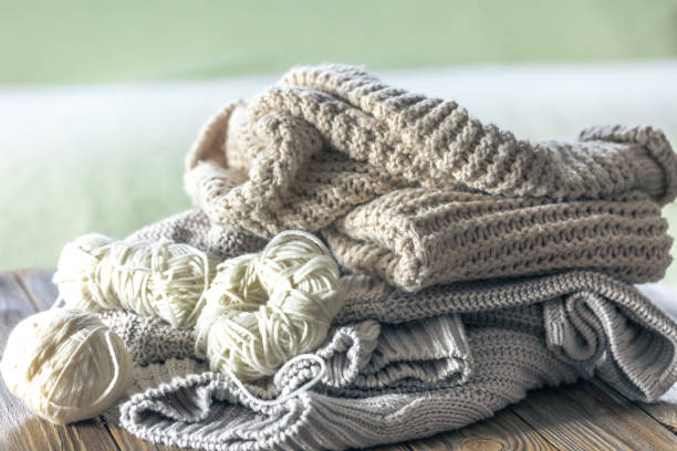 istock Stack of cozy knitted sweaters on wooden background. 2097857228