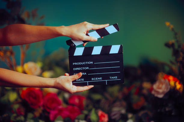 花を背景に映画のスレートを手にする監督 - film slate movie prop producer ストックフォトと画像