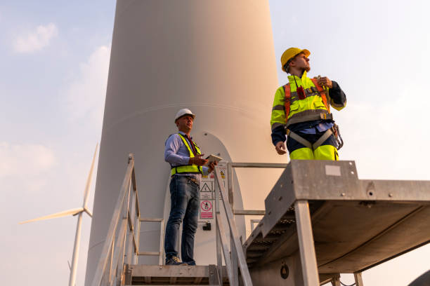 istock Engineer surveyor and manager wearing uniform walking holding box inspection and tablet work in wind turbine farms rotation to electricity, alternative renewable energy for clean power energy concept. 2097978523
