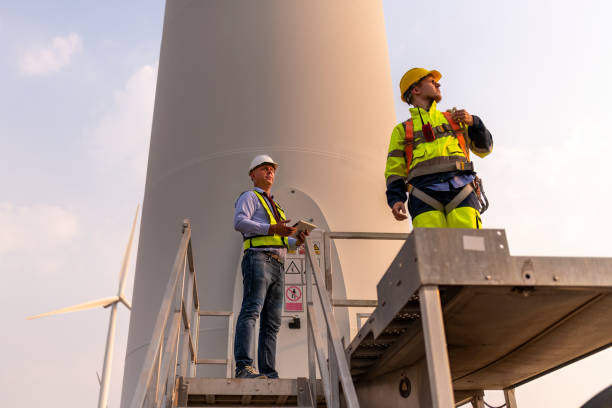 istock Engineer surveyor and manager wearing uniform walking holding box inspection and tablet work in wind turbine farms rotation to electricity, alternative renewable energy for clean power energy concept. 2097978527