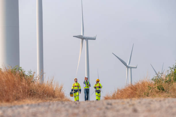 istock Engineer surveyor and manager wearing uniform walking holding box inspection and tablet work in wind turbine farms rotation to electricity, alternative renewable energy for clean power energy concept 2097981640