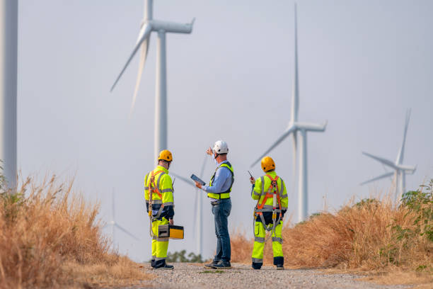 istock Engineer surveyor and manager wearing uniform walking holding box inspection and tablet work in wind turbine farms rotation to electricity, alternative renewable energy for clean power energy concept 2097981641