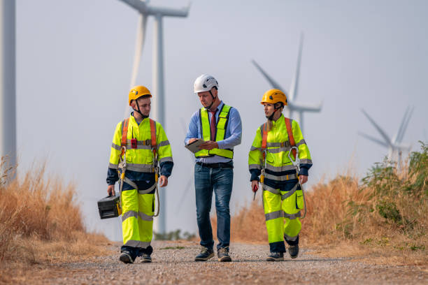 istock Engineer surveyor and manager wearing uniform walking holding box inspection and tablet work in wind turbine farms rotation to electricity, alternative renewable energy for clean power energy concept 2097982150