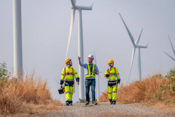 istock Engineer surveyor and manager wearing uniform walking holding box inspection and tablet work in wind turbine farms rotation to electricity, alternative renewable energy for clean power energy concept 2097982151