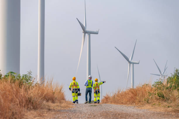 istock Engineer surveyor and manager wearing uniform walking holding box inspection and tablet work in wind turbine farms rotation to electricity, alternative renewable energy for clean power energy concept 2097982157