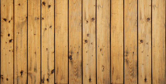 A wooden board with a grainy texture and a light brown color. The board is long and narrow, and it is a part of a larger wooden structure. The board is not very detailed, but it has a rustic