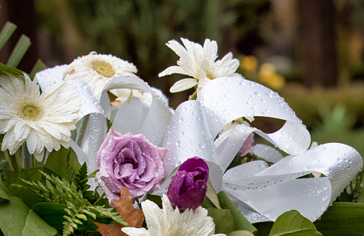 Fresh flower arrangement in cemtery in spring rain