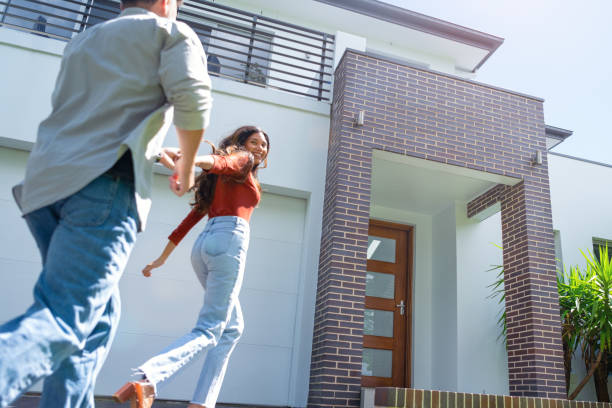 istock Couple joyfully running into their new home. 2098015091