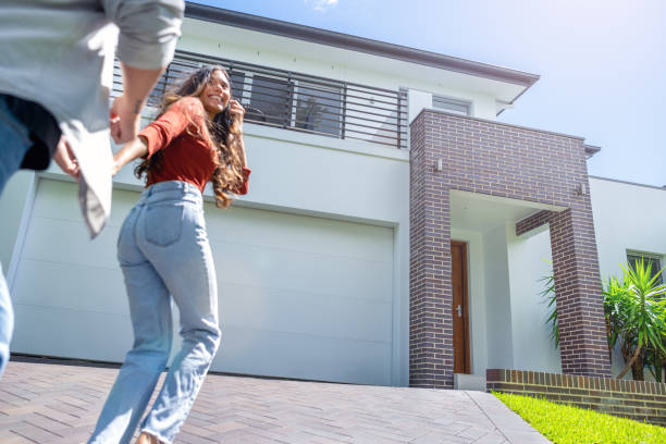 Couple joyfully running into their new home.