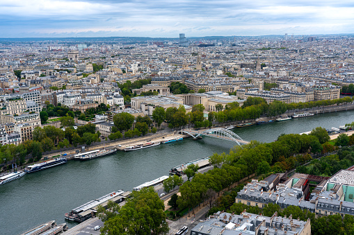 View of the predominantly white houses on Quai Voltaire in the centre of Paris, France. View also of the Seine. Photo was taken from the Pont des Arts