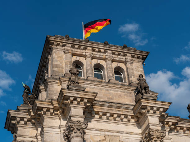 German flags waving atop the Reichstag with glass dome. Government building on Platz der Republik in Berlin. The seat of Bundestag, parlament in Germany. Copy space