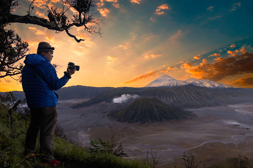 Young man meets the sunrise at the Bromo Tengger Semeru National Park on the Java Island, Indonesia.