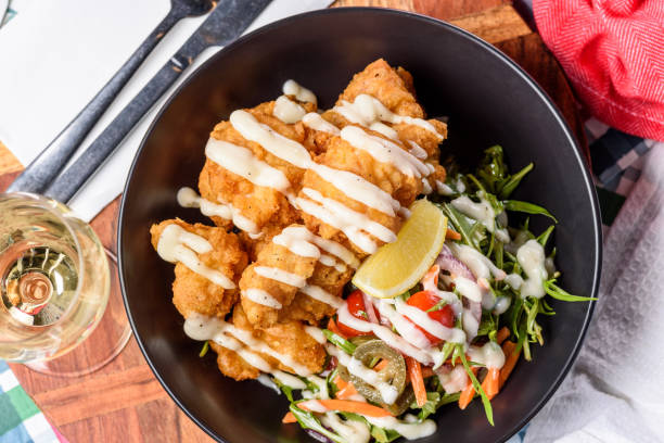 a serving of deep fried fish pieces with a white sauce - fish and chips cafe restaurant salad zdjęcia i obrazy z banku zdjęć