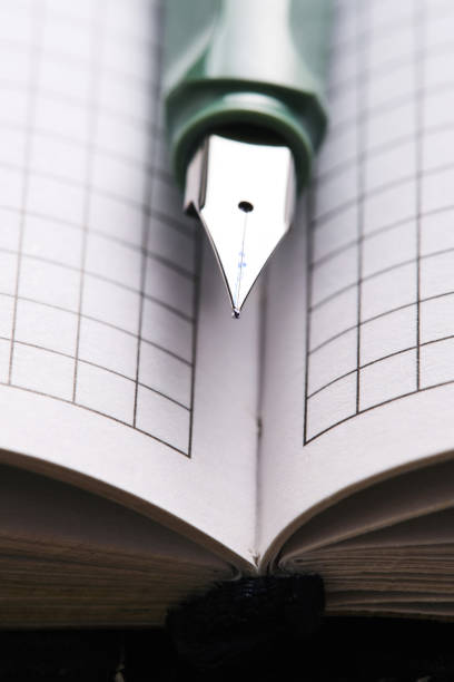 istock Green fountain pen lies on white sheets checkered notebook. 2098175663