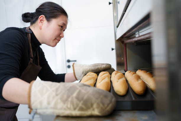 istock Woman taking out bread from oven 2098188871