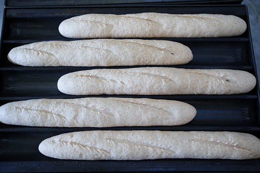 A freshly baked loaf of bread on an oven grill on a table cools after baking.