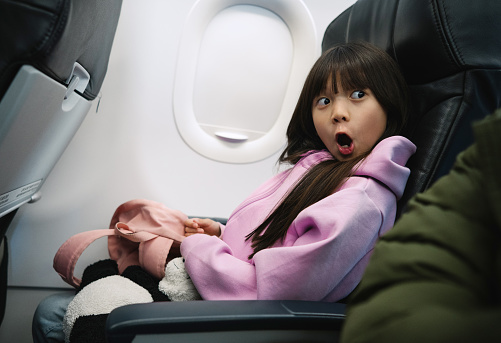 Cute little girl travelling by plane