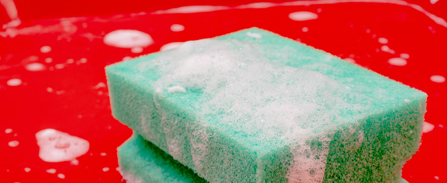 Close-up of soap sud (bubbles foam) in green colors. Beautiful defocused bokeh light.