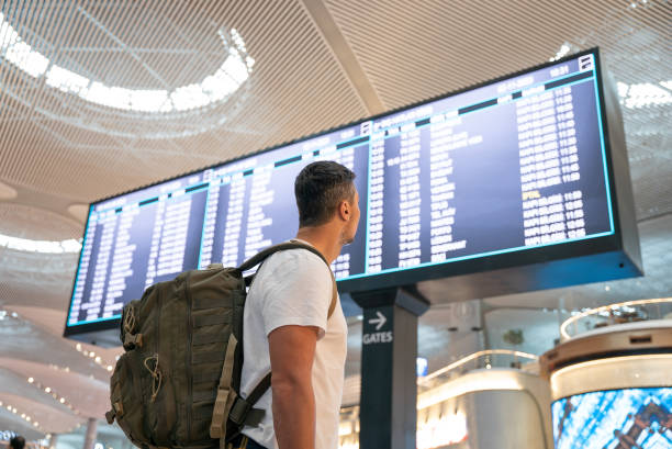 istock Man with backpack in airport near flight timetable 2098259654
