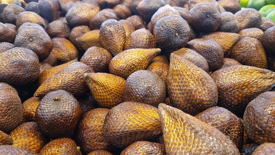 Bunch of snakefruit (Salacca zalacca) at the traditional market. Snakefruit is one of the tropical fruits that has a sour and sweet taste. Known as salak pondoh and widely cultivated by farmers.