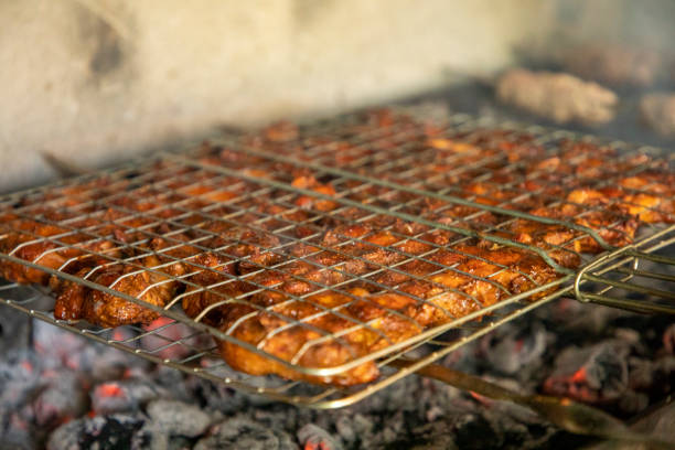 istock frying a chicken leg in a hot charcoal 2098314044