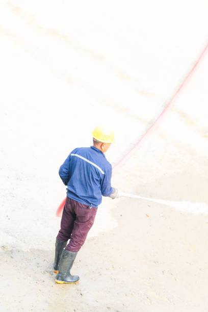 Man using water hose to clean the ground