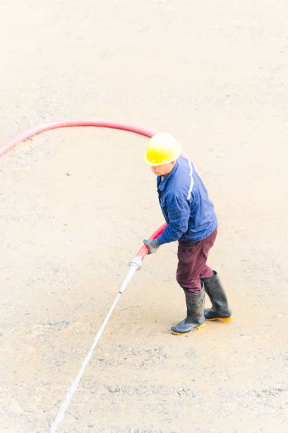 istock Man using water hose to clean the ground 2098321850