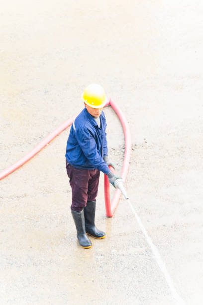istock Man using water hose to clean the ground 2098324525