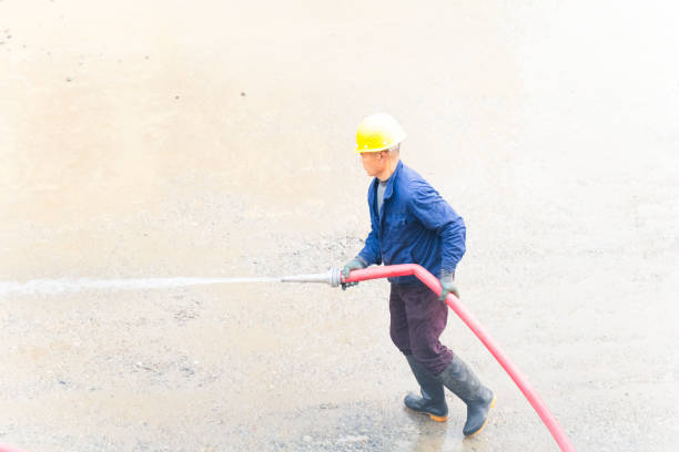 Man using water hose to clean the ground