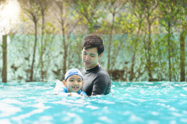 istock Father and son swimming together. 2098338878