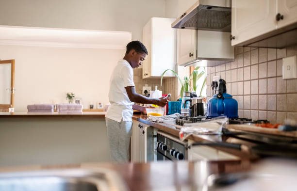 istock Teenage boy whisks eggs in the mixing bowl in kitchen 2098385526