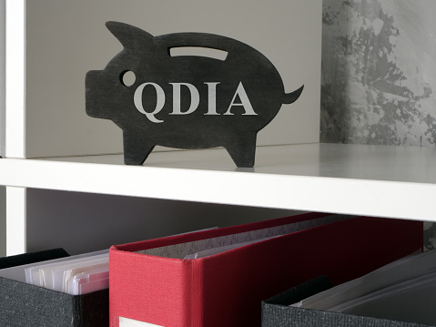 A piggy bank with abbreviation QDIA Qualified default investment alternative.
