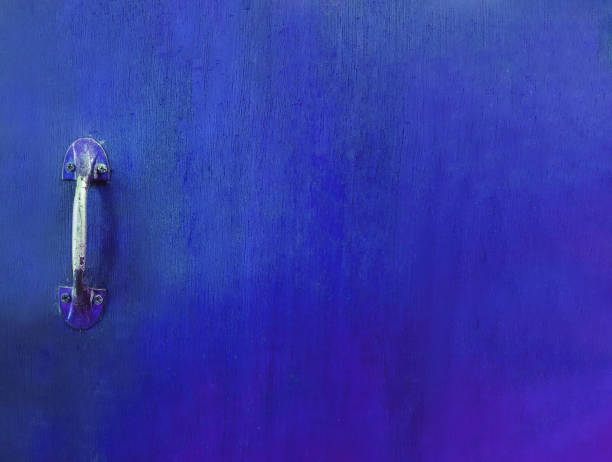 Stainless steel handle door on blue wooden background with copy space.