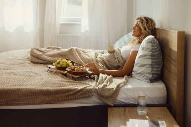 istock Smiling woman relaxing during morning in a bed. 2098412920