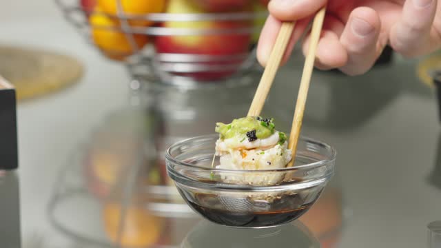The video showcases dipping a juicy roll into soy sauce