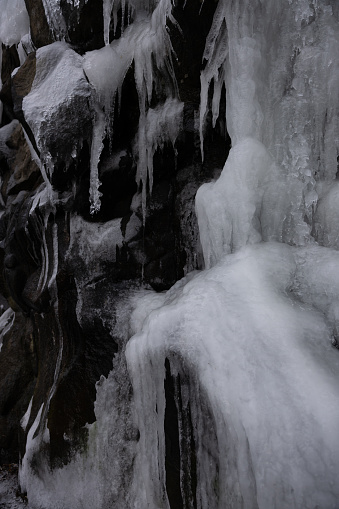 An Icy waterfall cascades into a winter lake