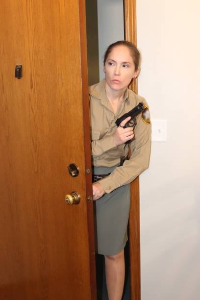 istock female police officer with gun 2098432097