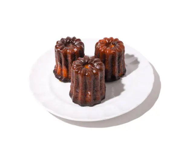 caneles on a plate with white background