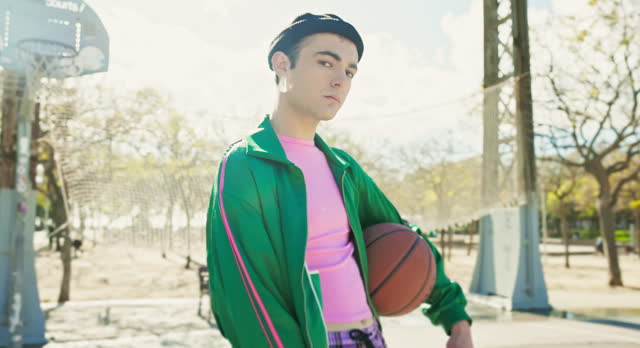 Young man with basketball on public park sports court