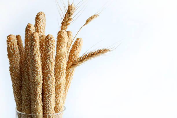 Long artisanal breadsticks with sesame seeds isolated on white background. Bakery products. Copy space. Overhead view.